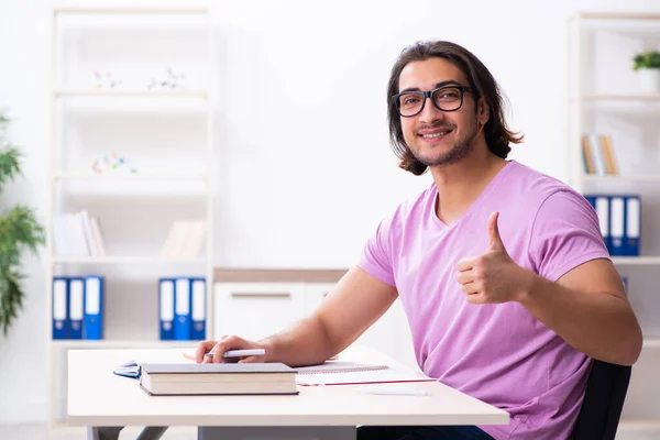 Ung manlig student förbereder sig för tentor i klassrummet — Stockfoto