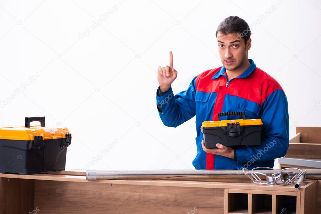 Young handsome male carpenter working indoors