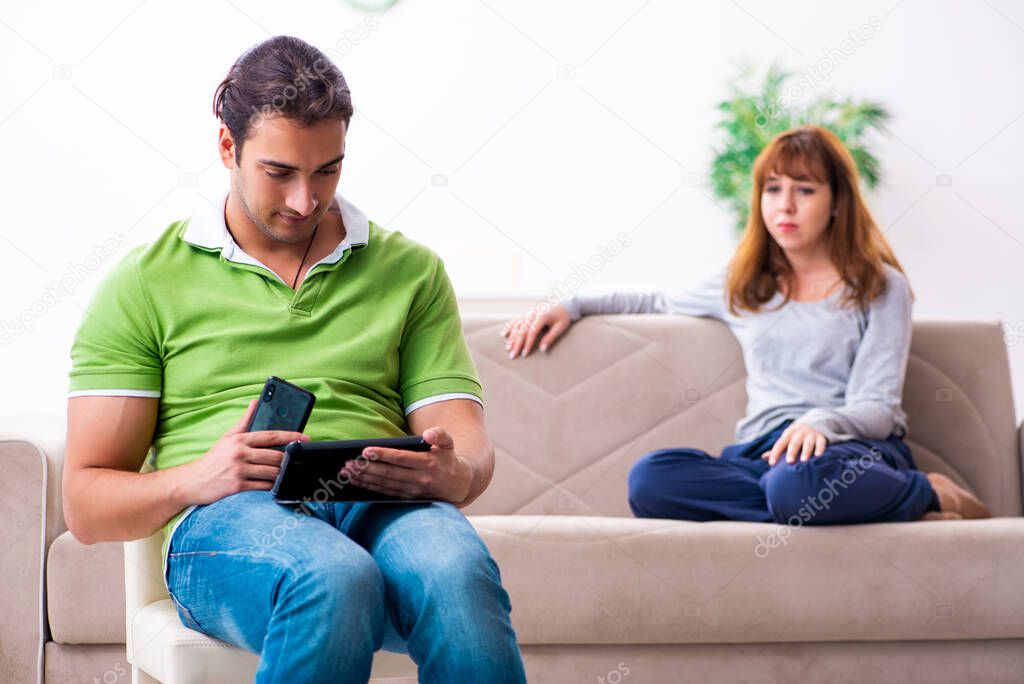 Young couple in gadget dependency concept