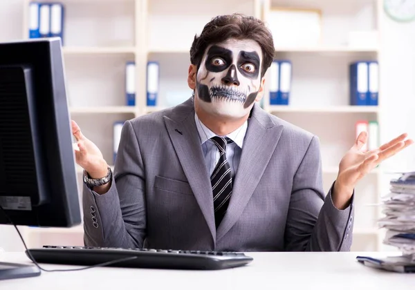 Businessmsn con maschera viso spaventoso che lavora in ufficio — Foto Stock