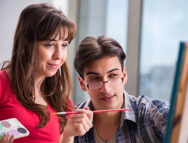 Artist coaching student in painting class in studio — Stock Photo, Image