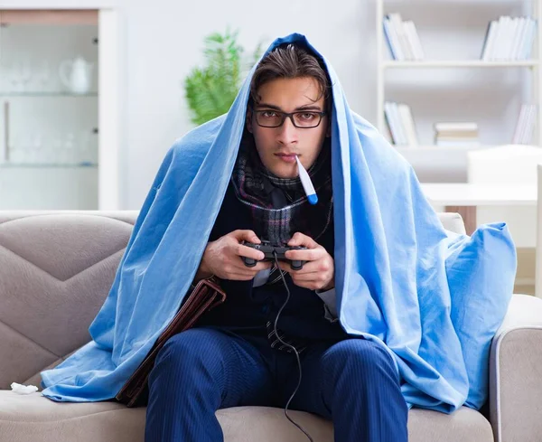 Employee suffering from flue playing computer game at home — Stock Photo, Image