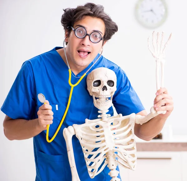 Grappige dokter met skelet in ziekenhuis — Stockfoto