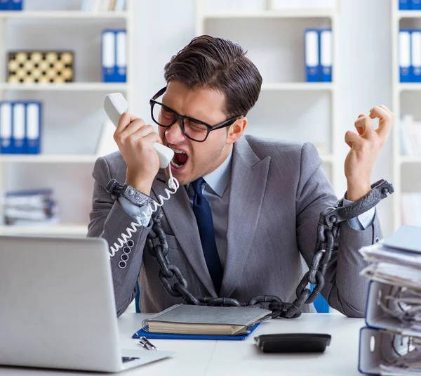 Upptagen anställd fastkedjad vid sitt skrivbord — Stockfoto