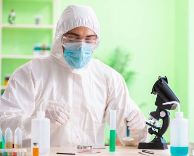 Laboratuvarda yeni bir deney üzerinde çalışan kimyager.