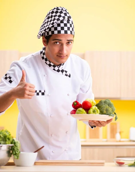 Jonge professionele kok bereidt salade thuis — Stockfoto