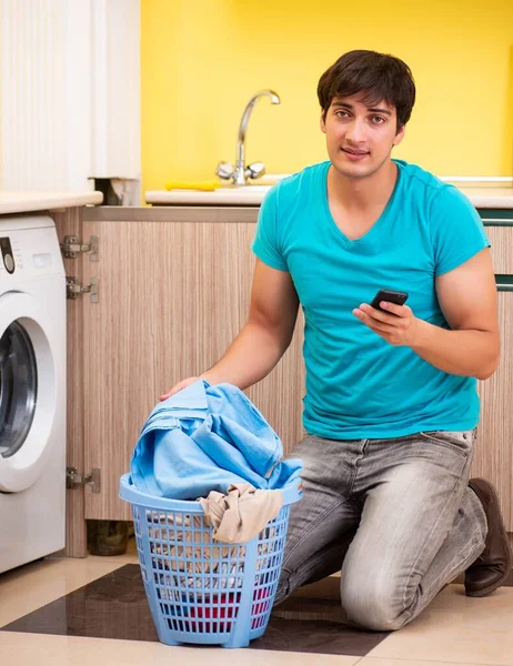 Молодой муж стирает дома. — стоковое фото