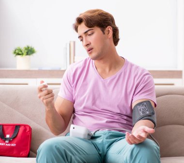 Evde ilk yardım çantasıyla hasta bir adam var.