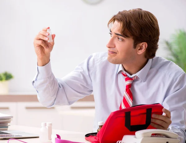 Man with first aid kit in the office — Stock Photo, Image