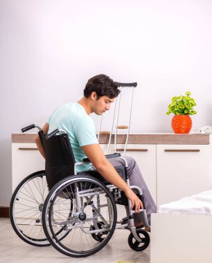 Genç yakışıklı engelli adam evde iyileşiyor.