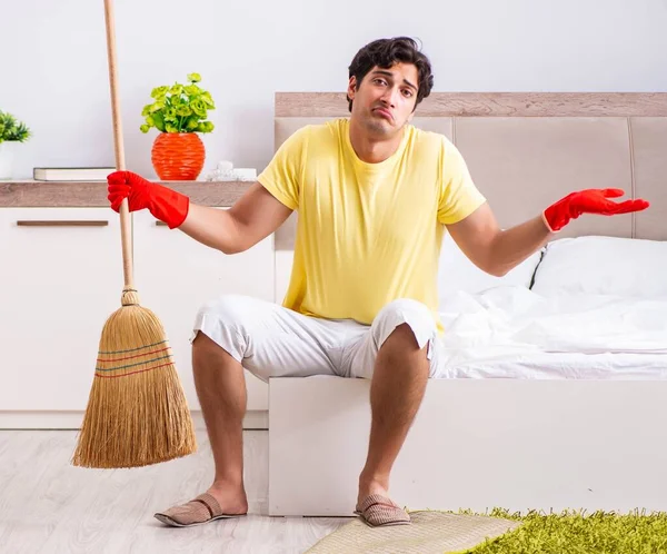 Fiatal jóképű férfi takarítás a hálószobában — Stock Fotó