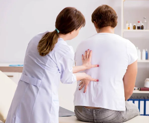 Άνδρας ασθενής επισκέπτεται νεαρή γυναίκα γιατρό χειροπρακτικός — Φωτογραφία Αρχείου