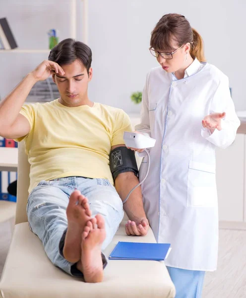 Médico joven revisando pacientes presión arterial —  Fotos de Stock