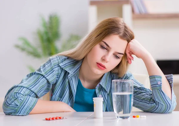 Mujer tomando pastillas para hacer frente al dolor — Foto de Stock