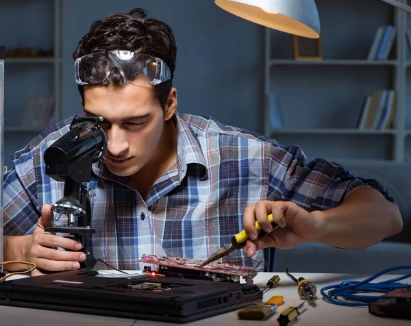 Réparateur essayant de réparer ordinateur portable avec miscroscope — Photo