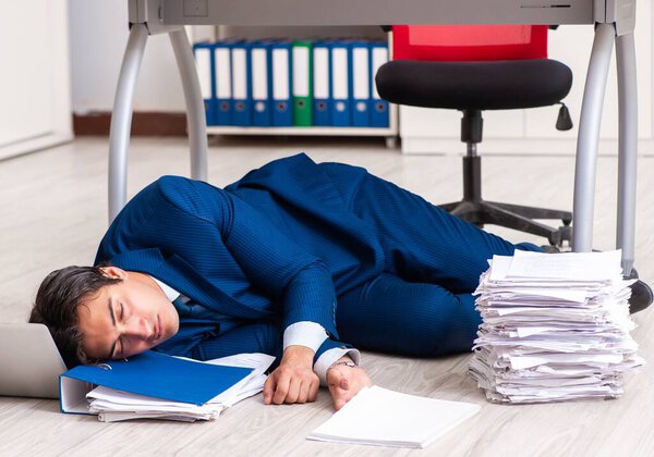Tired exhausted businessman working overtime in office
