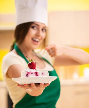 Genç aşçı mutfakta kek pişiriyor.