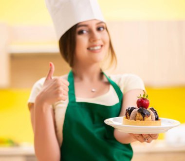 Genç aşçı mutfakta kek pişiriyor.