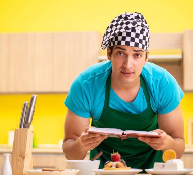 Adam evde pasta hazırlıyor.