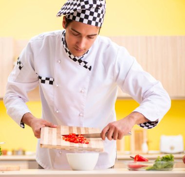 Genç profesyonel aşçı evde salata hazırlıyor.