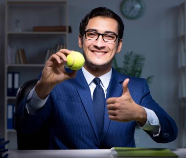 Tenis topu taşıyan genç bir çalışan.