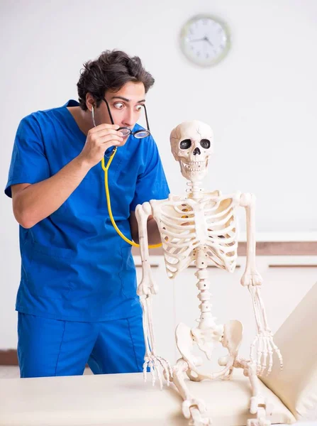 Lustiger Arzt mit Skelett im Krankenhaus — Stockfoto