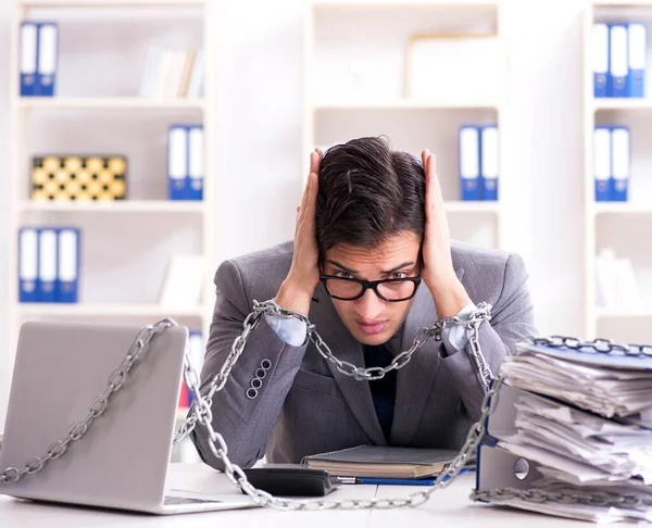 Upptagen anställd fastkedjad vid sitt skrivbord — Stockfoto