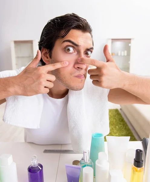 Young handsome man in the bathroom in hygiene concept — Stock Photo, Image