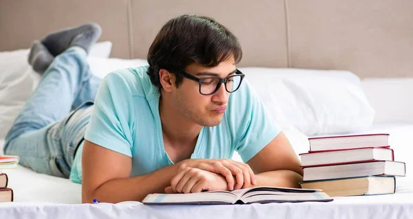 Student preparing for exams at home in bedroom lying on the bed — Stock Photo, Image