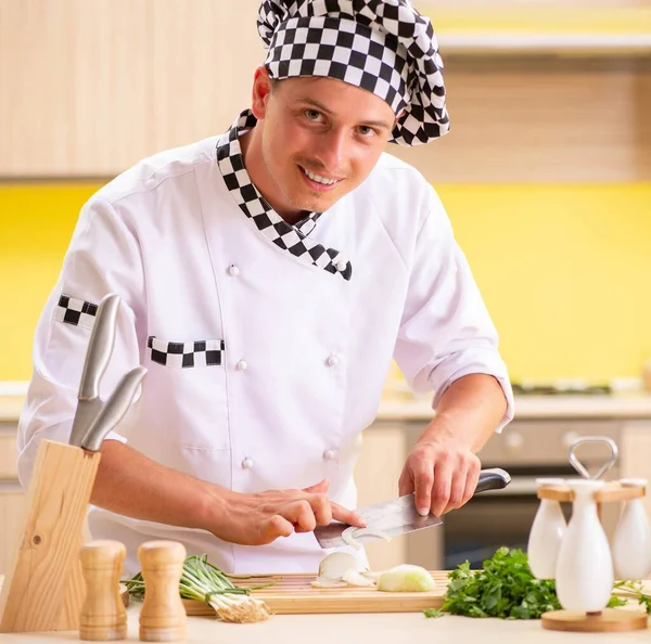 Joven cocinero profesional preparando ensalada en la cocina — Foto de Stock