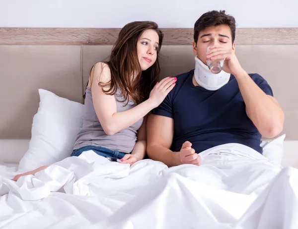 Loving wife taking care of injured husband in bed — Stock Photo, Image