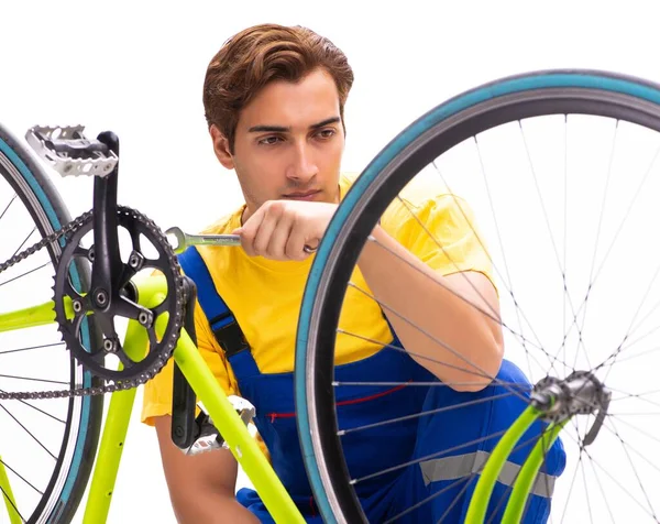 Homem reparando sua bicicleta isolada no fundo branco — Fotografia de Stock