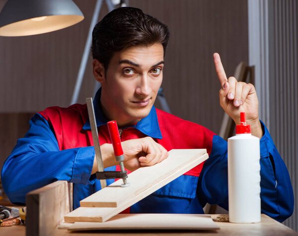 Young man gluing wood pieces together in DIY concept