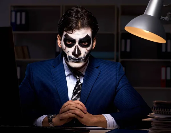戴着可怕面具的商人在办公室工作到很晚 — 图库照片