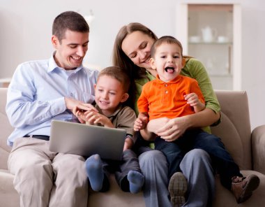 Genç aile internette sörf yapıyor ve fotoğraflara bakıyor.