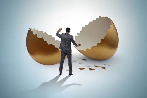 Businessman breaking out of golden egg — Stock Photo, Image