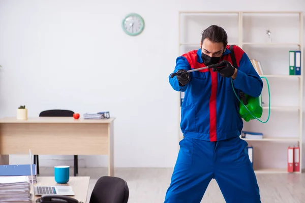 Contratista masculino joven desinfectando oficina — Foto de Stock