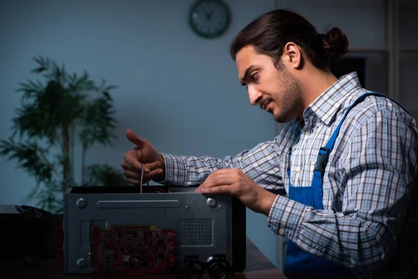 夜のワークショップでコンピュータを修復する若い男性技術者 — ストック写真