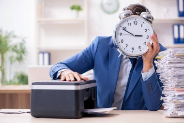 Kopyalama makinesinde çalışan genç bir erkek.