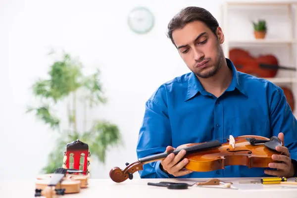 Hombre joven reparador reparando violín — Foto de Stock