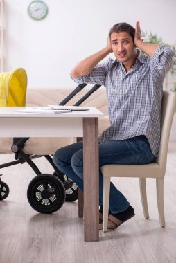 Genç baba yeni doğan bebeğe evde bakıyor.