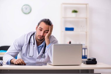 Klinikte çalışan yakışıklı genç erkek doktor.