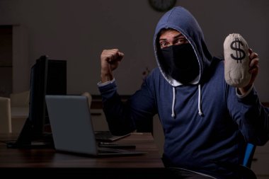 Erkek bilgisayar korsanı, güvenlik duvarını geç saatlerde hackliyor.