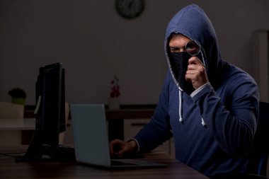 Erkek bilgisayar korsanı, güvenlik duvarını geç saatlerde hackliyor.