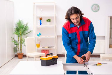 Genç erkek marangoz içeride çalışıyor.