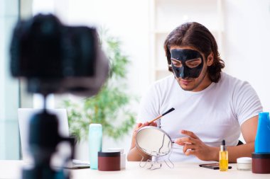 Genç erkek kozmetikçi blogu için video kaydediyor.