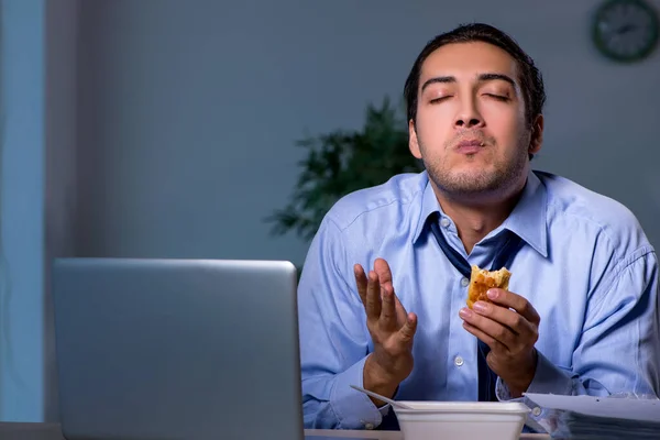 Funcionário com fome trabalhando até tarde no escritório — Fotografia de Stock