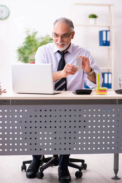 Old sick employee suffering at workplace — Stock Photo, Image