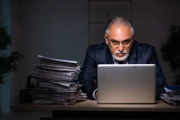 Viejo empleado trabajando hasta tarde en el lugar de trabajo — Foto de Stock