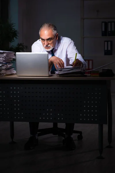 Viejo empleado trabajando hasta tarde en el lugar de trabajo — Foto de Stock